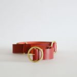 a leather belt with detail of brass hardware
