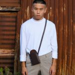 male model wearing brown leather phone pouch