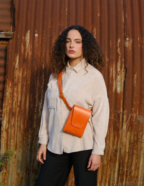 a female model wears a leather belt bag across her body