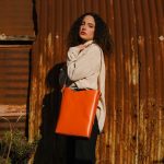a female model wears an orange tote bag